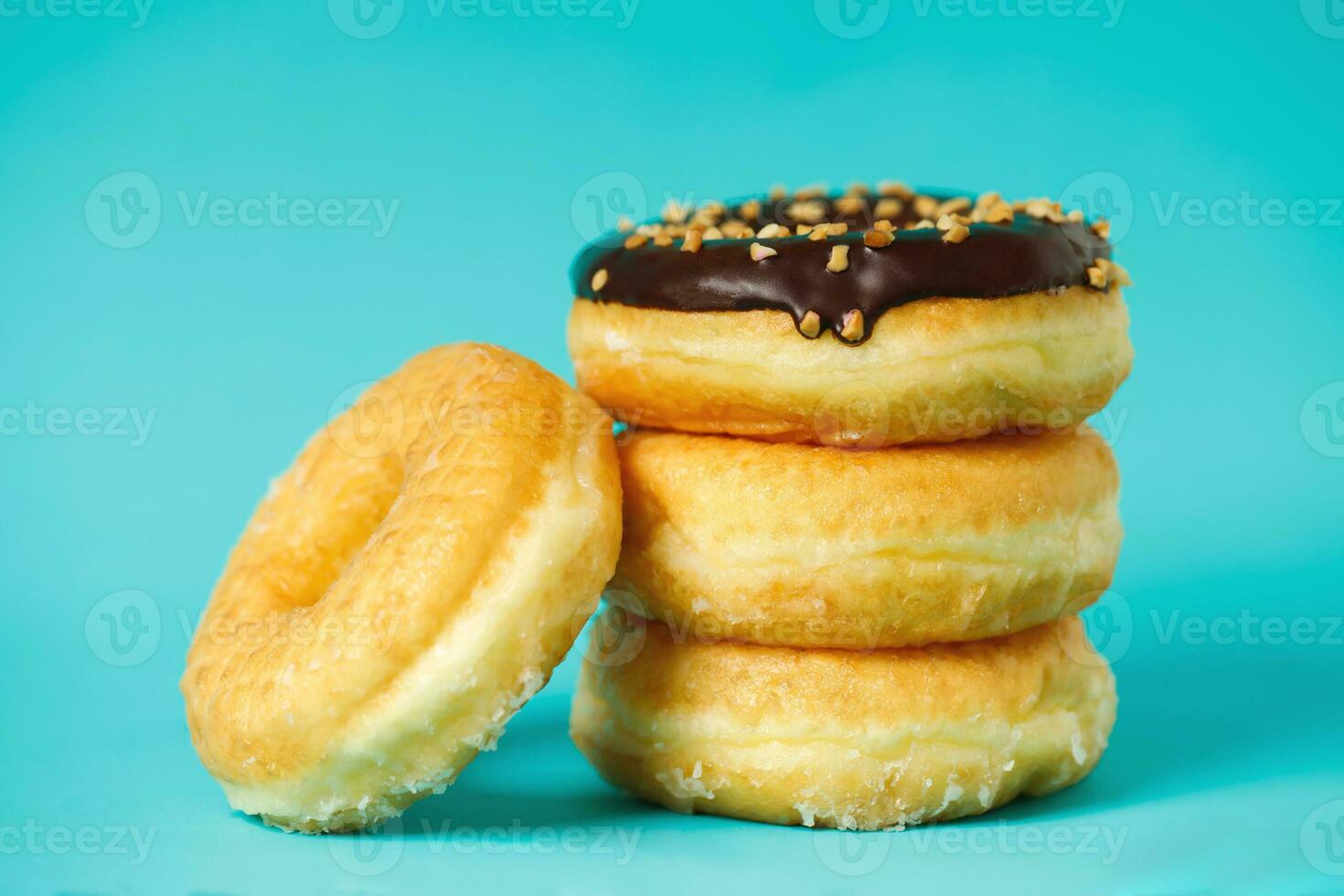 diverse munkar med choklad frosting, topping strössel munkar färgglad variation och variation av smaker mix av flerfärgade söta munkar med frostat strös på blå bakgrund. toppvy foto