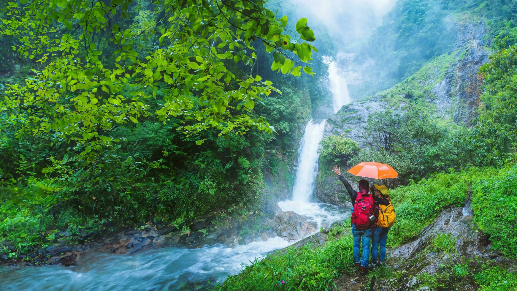 älskare asiatisk man och asiatisk kvinnor resa natur resa de högsta vattenfall i Chiang Mai mae-pan vattenfall regnig säsong på doi intanon. foto