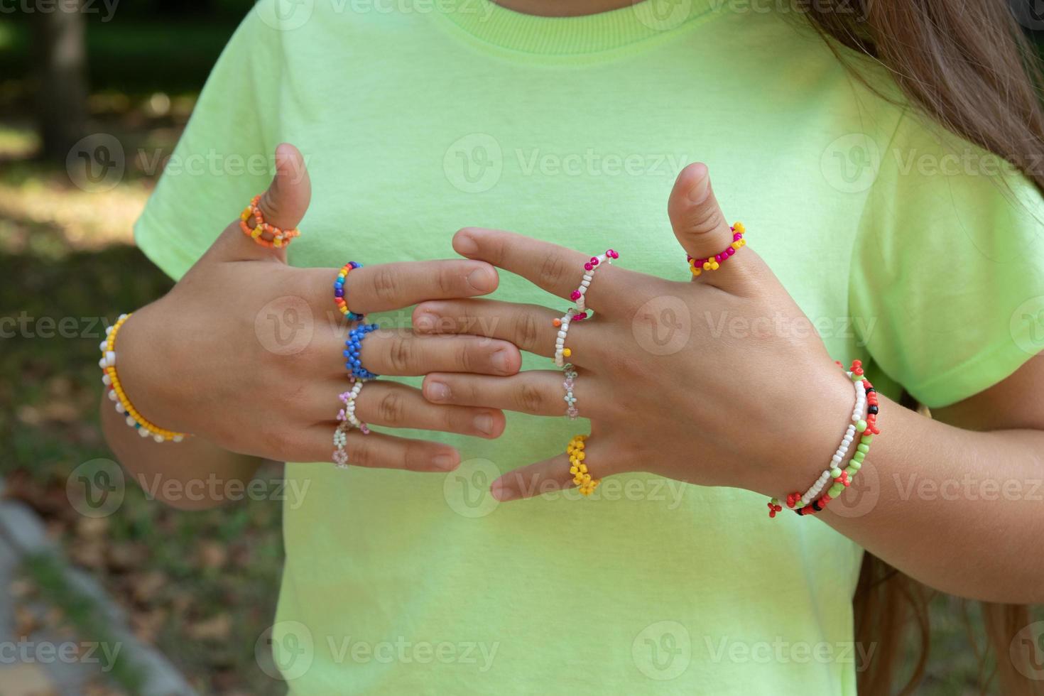 ringar och armband - pärldekorationer på flickans händer foto
