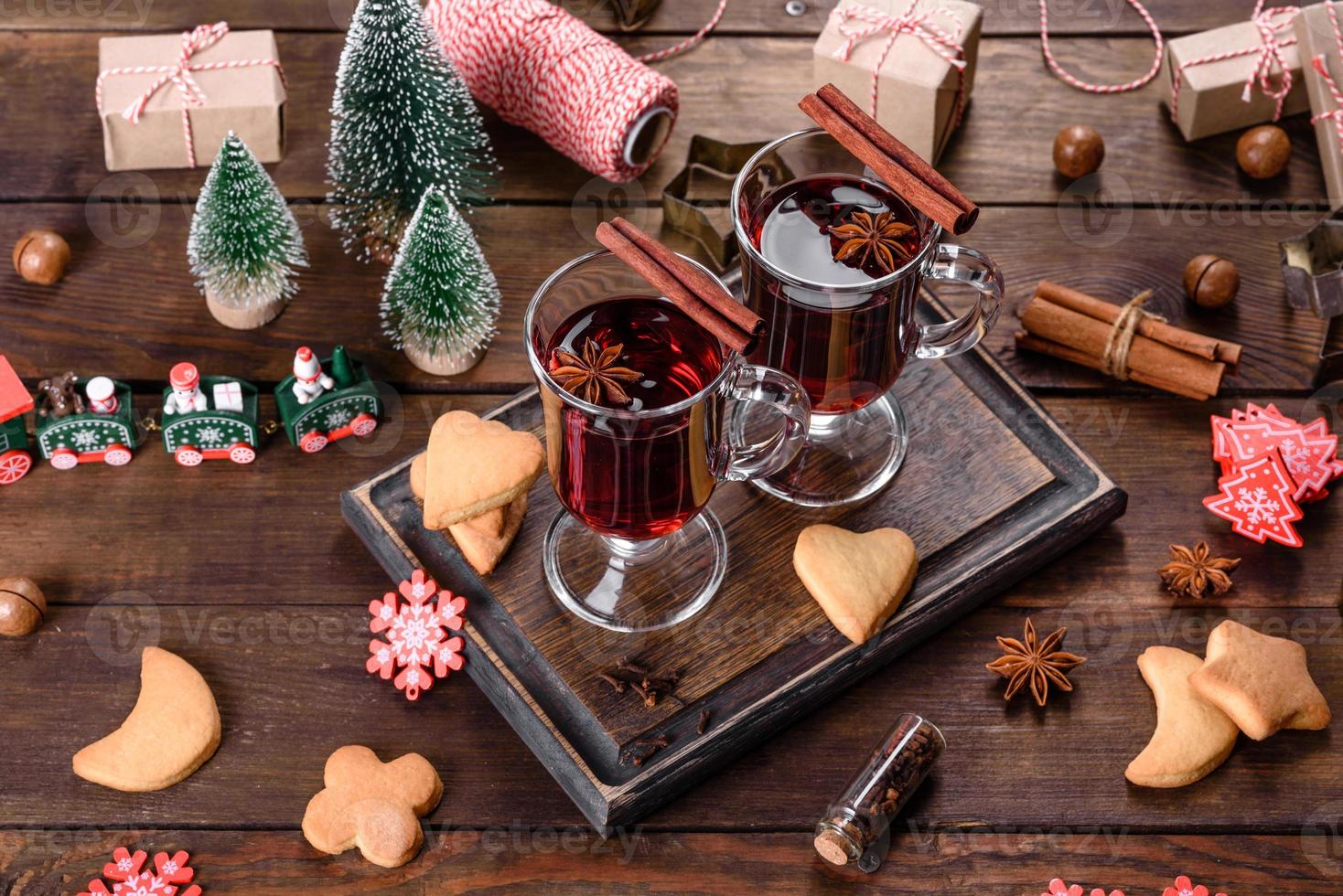 jul glöggrött vin med kryddor och frukter på ett mörkt bord. foto