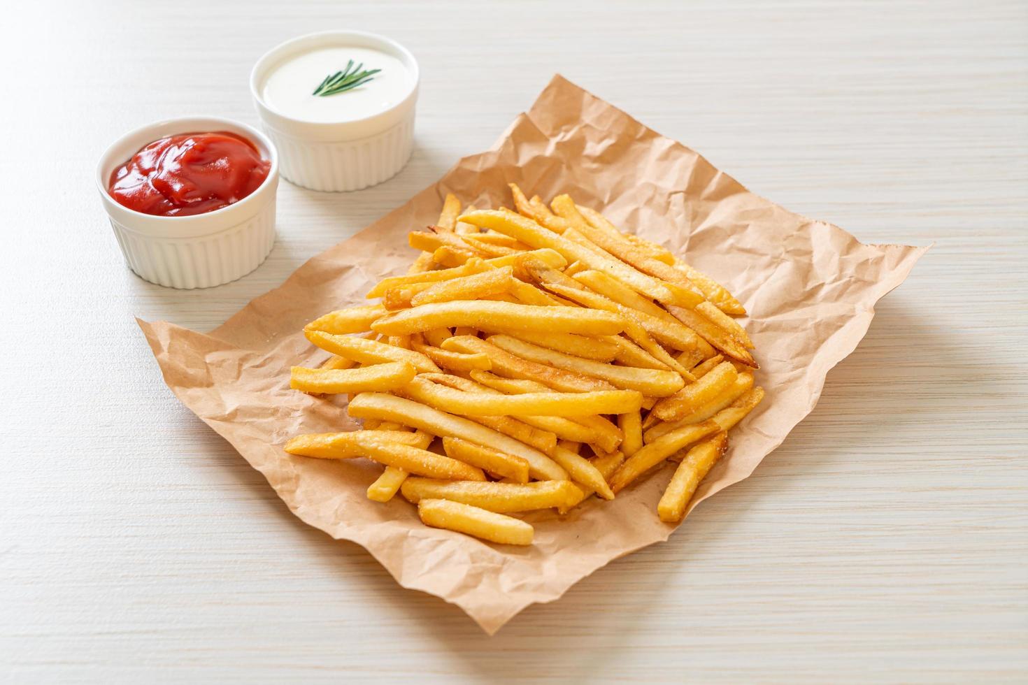 pommes frites med gräddfil och ketchup foto