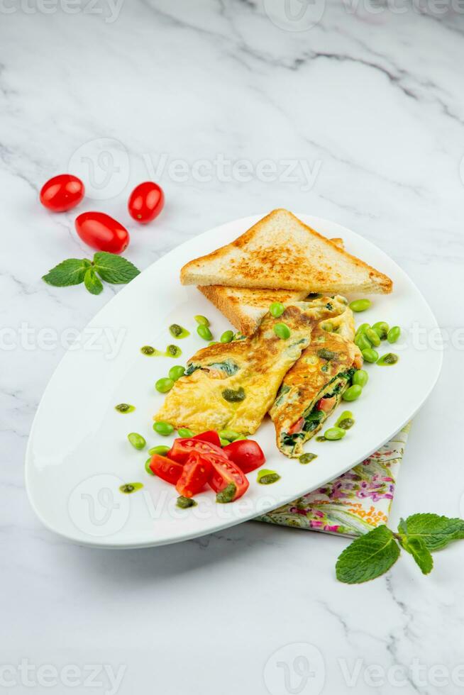 frukost av ägg och grönsaker med körsbär tomater och skivor av bröd i en vit tallrik sida se foto