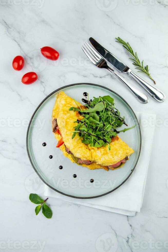 frukost av ägg med kött, örter och droppar av sås i en runda tallrik foto