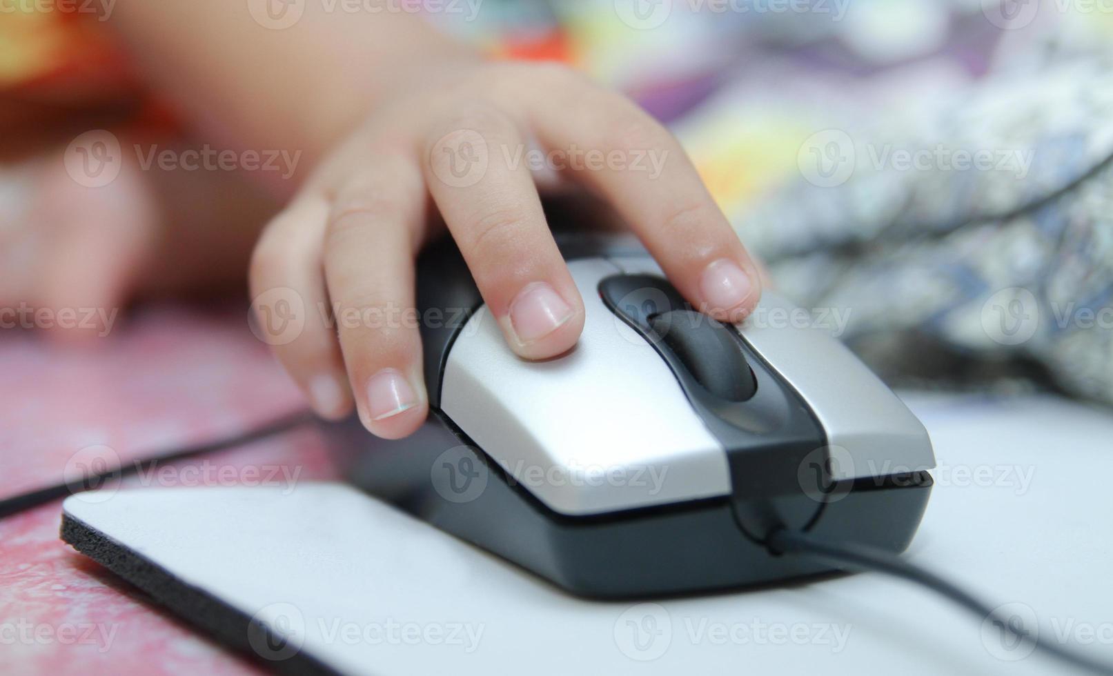 barnet lär sig online och spelar spel på datorn hemma. foto