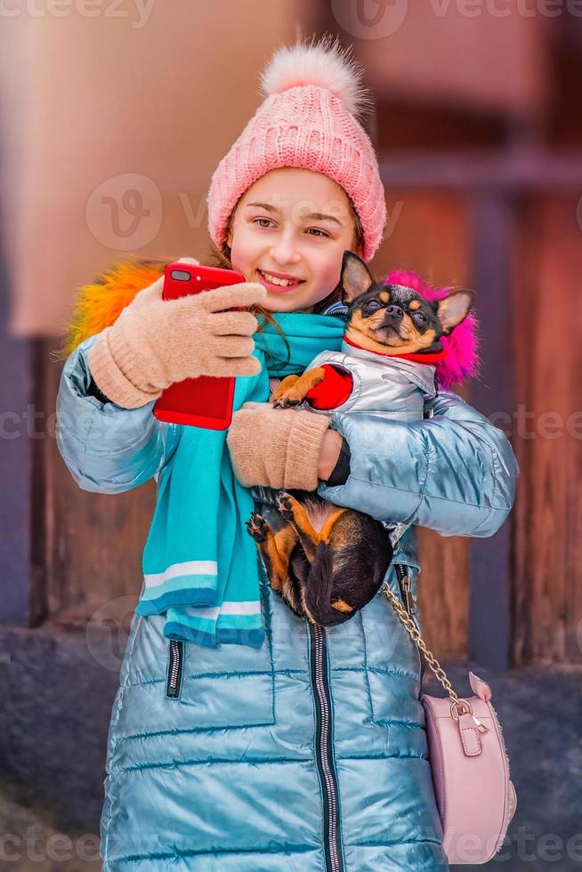 flicka och chihuahua gör självporträtt på smartphone under vinterdagen foto