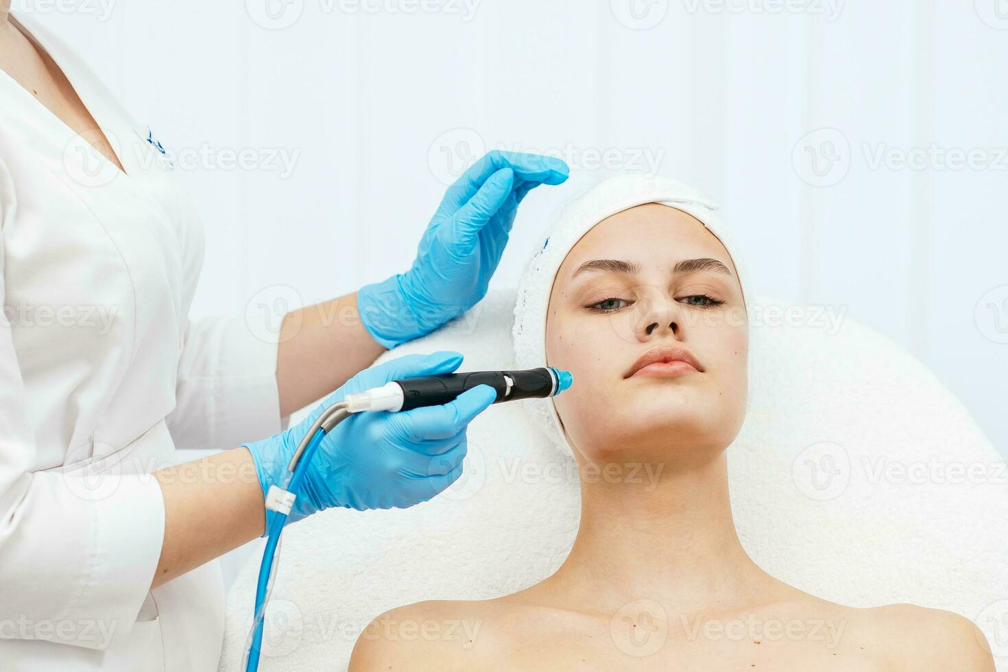 ansikte hud vård. närbild av kvinna få ansiktsbehandling hydro microdermabrasion peeling behandling på kosmetisk skönhet spa klinik. hydra Vakuum rengöringsmedel. exfoliering, föryngring och hydrering. kosmetologi. foto