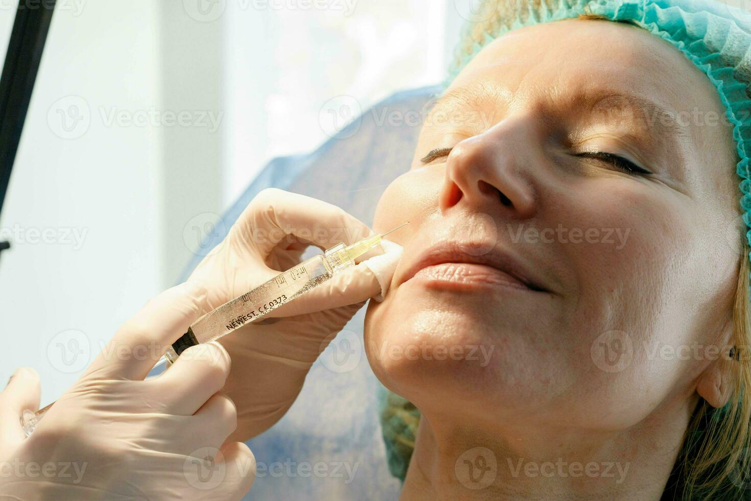 läkare kosmetolog gör injektioner i de panna för patient. foto