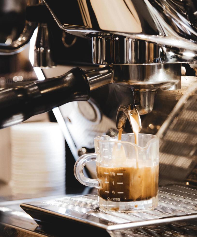espressomaskin som brygger ett kaffe foto