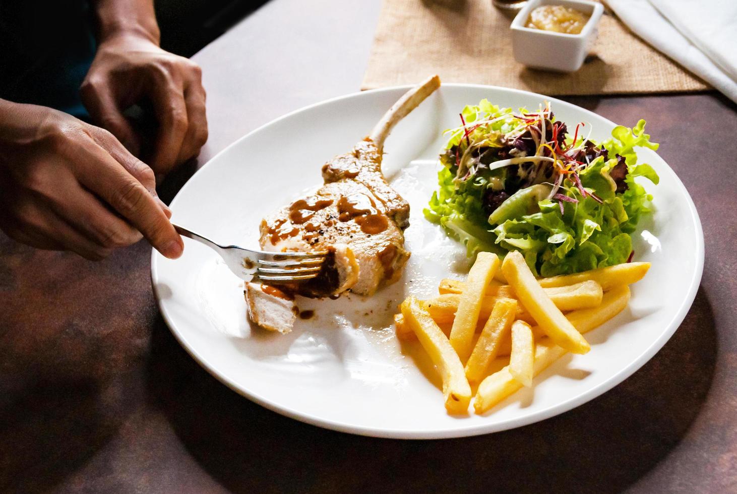 fläskkotlettstek med sallad och pommes frites foto