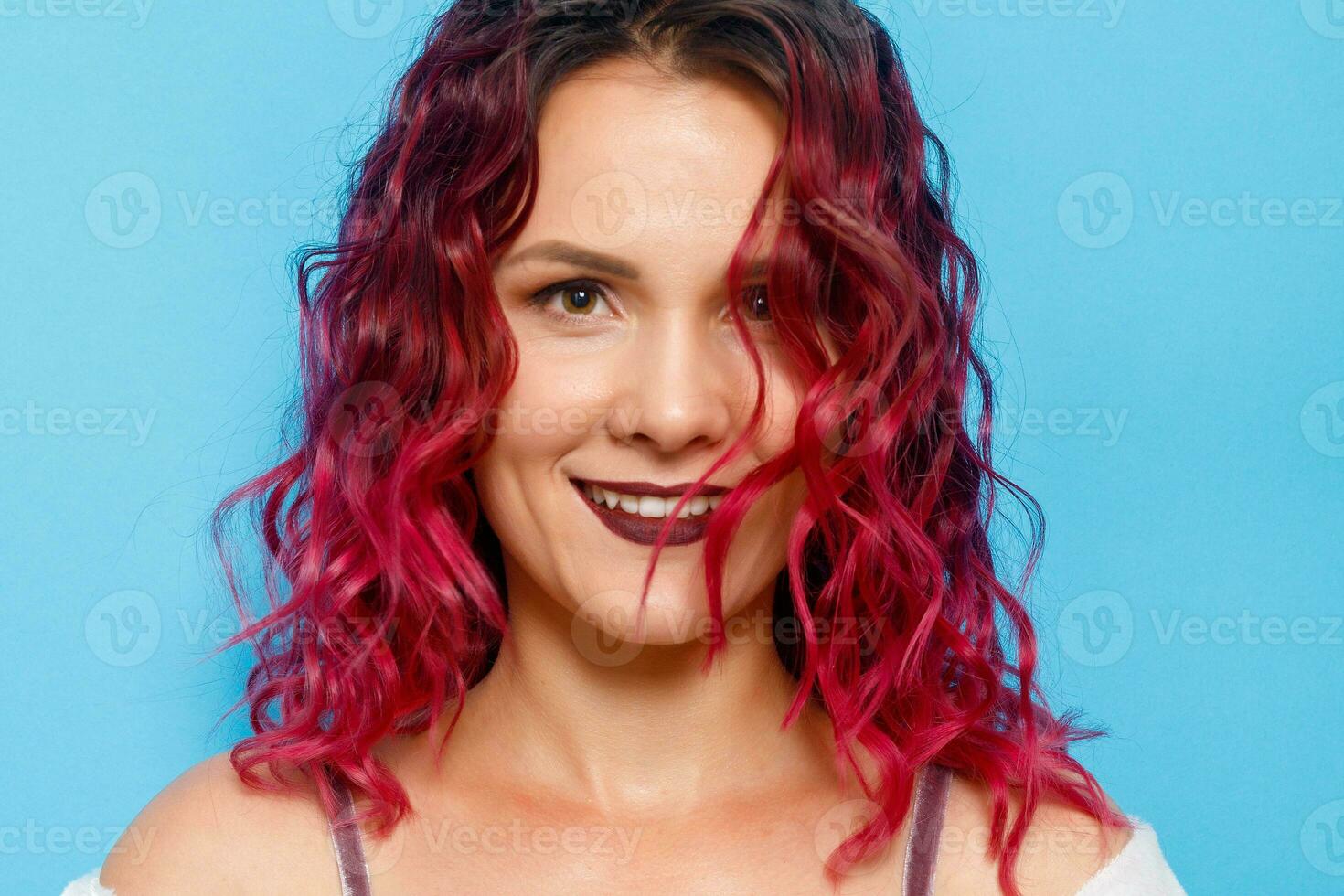 Lycklig ingefära röd hår flicka med fräknar leende ser på kamera foto