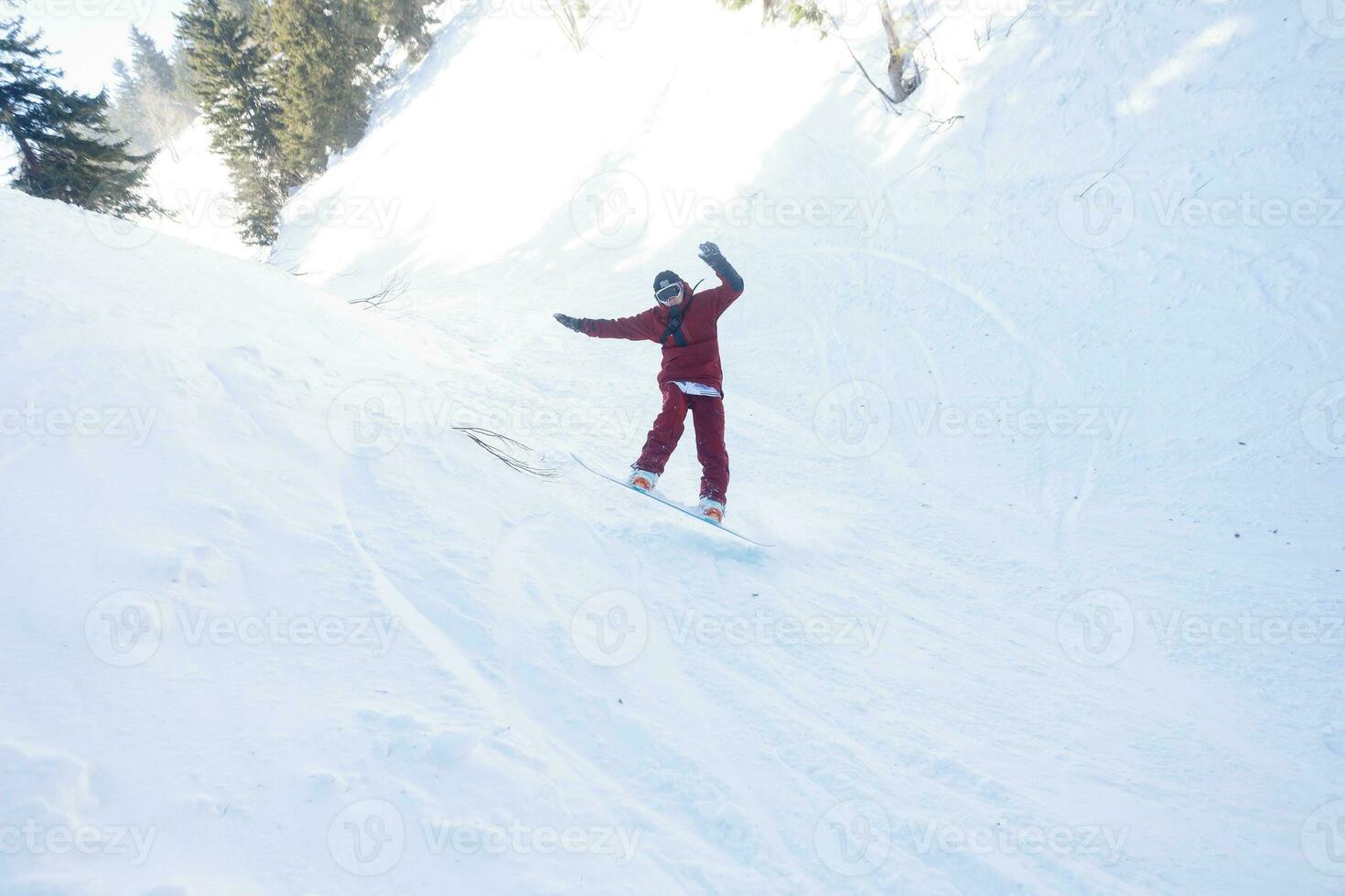 aktiva snowboardåkare Hoppar i bergen på en solig dag foto