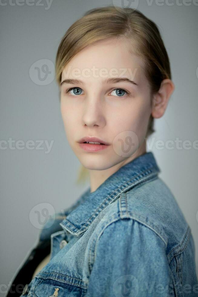 porträtt av en Söt ung blond flicka i en denim jacka foto