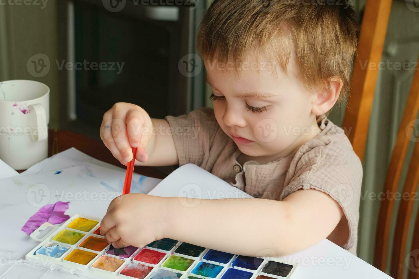 litet barn Hem fritid. liten pojke målning med färger. foto