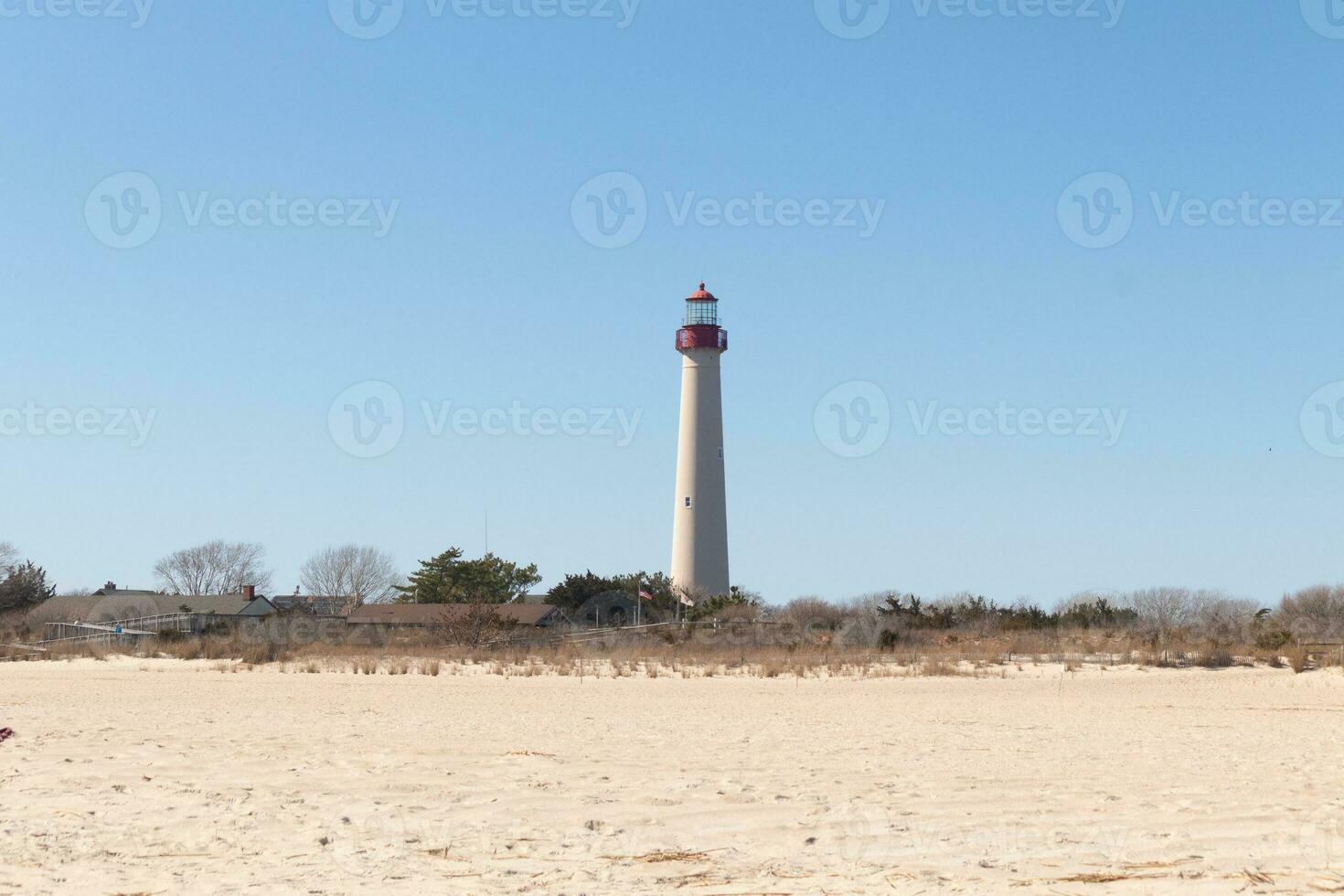 detta är cape Maj punkt fyr sett från de strand. de lång vit strukturera med röd metall serverar som en fyr av säkerhet. foto