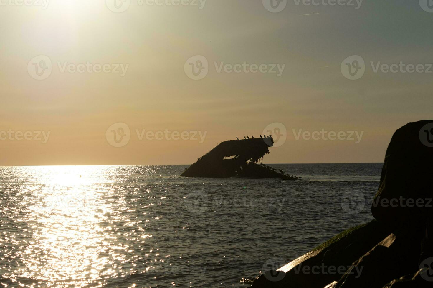 solnedgång strand i cape Maj ny jersey var du kan skaffa sig en bra se av de Sol gående ner tvärs över de hav och de bukt. de reflexion av de Sol på de vatten med de nedsänkt fartyg utseende så skön. foto