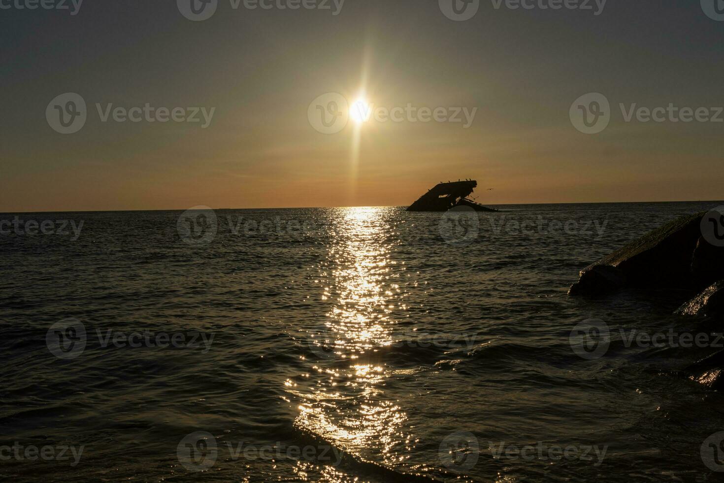 solnedgång strand i cape Maj ny jersey var du kan skaffa sig en bra se av de Sol gående ner tvärs över de hav och de bukt. de reflexion av de Sol på de vatten med de nedsänkt fartyg utseende så skön. foto