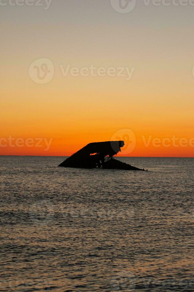 solnedgång strand i cape Maj ny jersey var du kan skaffa sig en bra se av de Sol gående ner tvärs över de hav och de bukt. de reflexion av de Sol på de vatten med de nedsänkt fartyg utseende så skön. foto