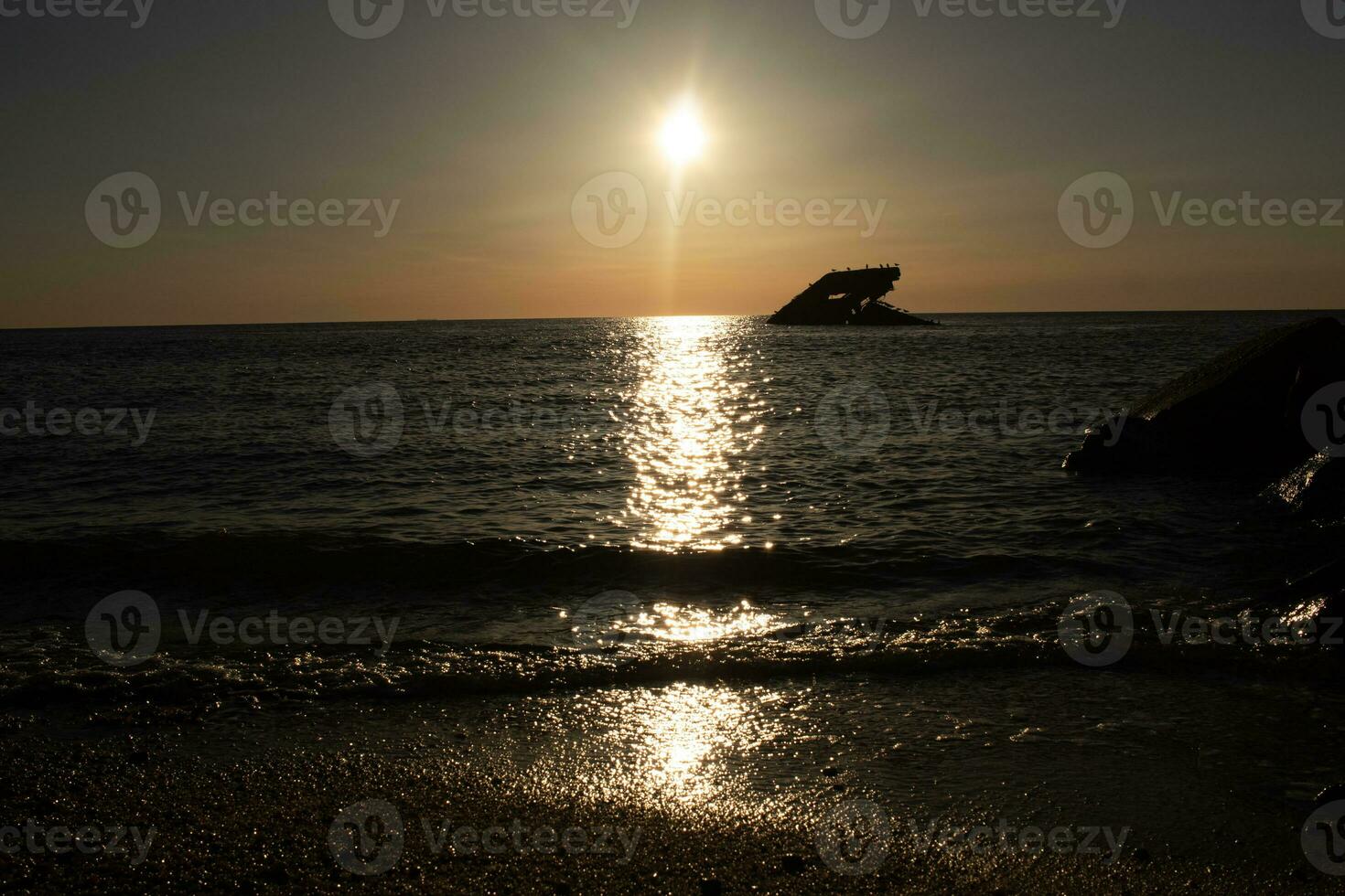 solnedgång strand i cape Maj ny jersey var du kan skaffa sig en bra se av de Sol gående ner tvärs över de hav och de bukt. de reflexion av de Sol på de vatten med de nedsänkt fartyg utseende så skön. foto