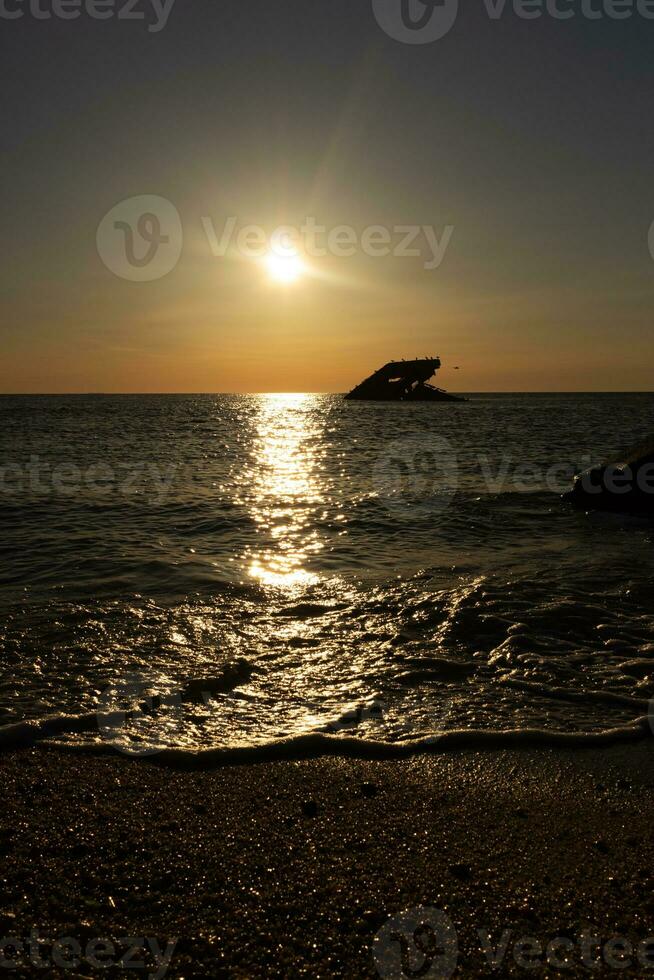 solnedgång strand i cape Maj ny jersey var du kan skaffa sig en bra se av de Sol gående ner tvärs över de hav och de bukt. de reflexion av de Sol på de vatten med de nedsänkt fartyg utseende så skön. foto