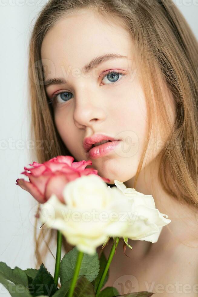 liten Söt flicka i rosa innehar de bukett av rosor. foto