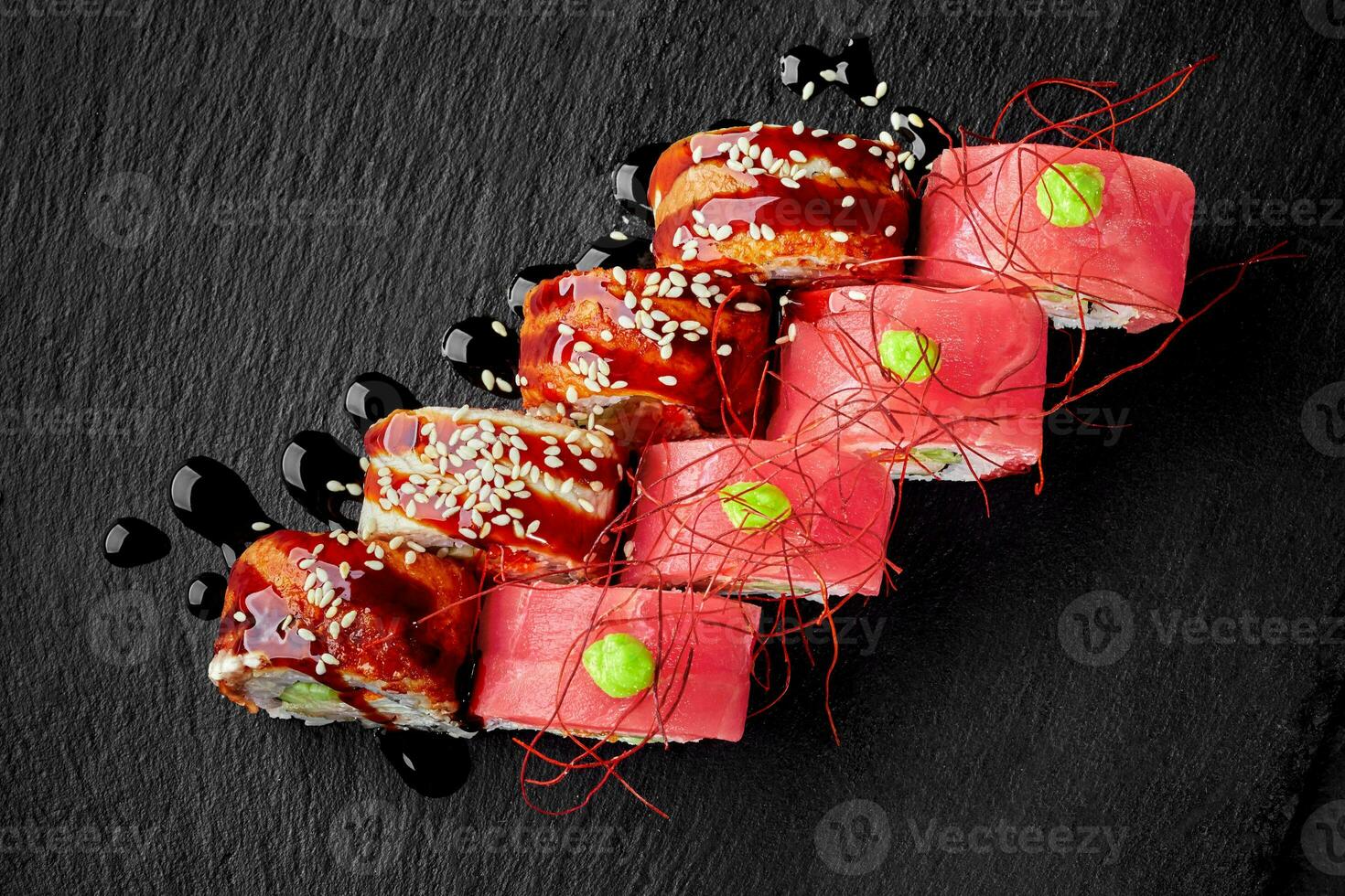 uramaki med ål, unagi sås, sesam och tonfisk, wasabi ito togarashi flingor foto
