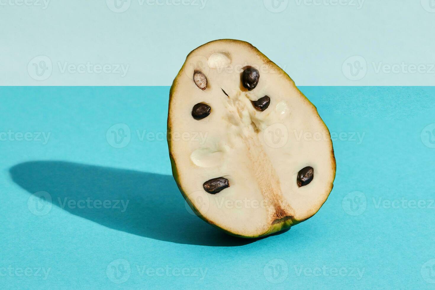 stänga upp hög kvalitet bild av halv av socker äpple, frukt av annona squamosa cherimoya, frukt sammansättning på blå pastell foto