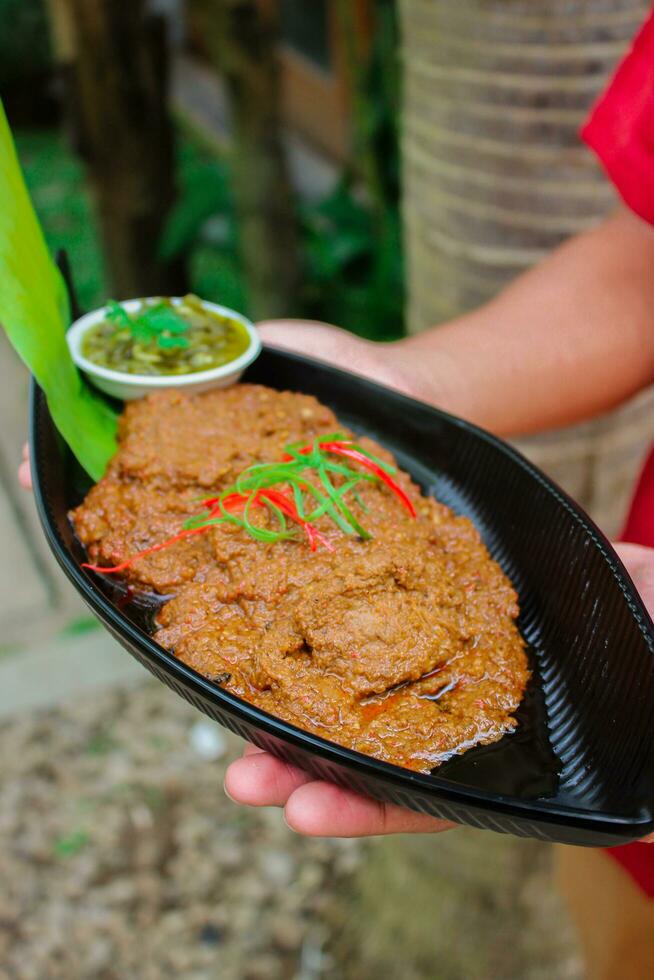 nötkött rendang är en Minang maträtt ursprung från de minangkabau område i väst sumatra, Indonesien. rendang har varit långsam kokta och bräserad i en kokos mjölk kryddat med en ört och krydda blandning foto