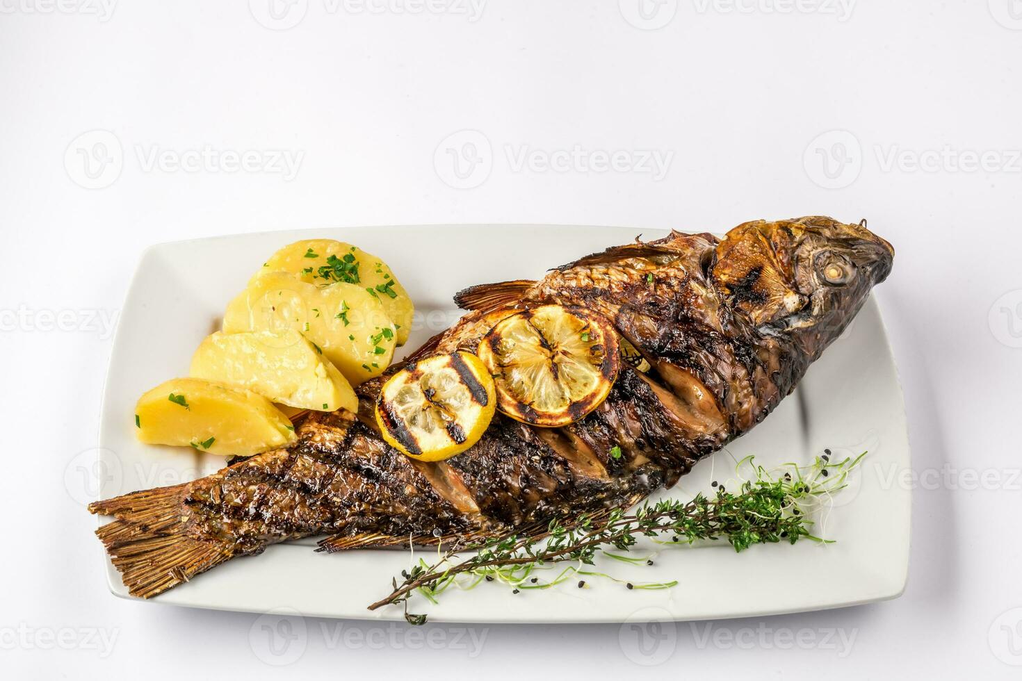 grillad karp fisk med rosmarin potatisar och citron, stänga upp foto