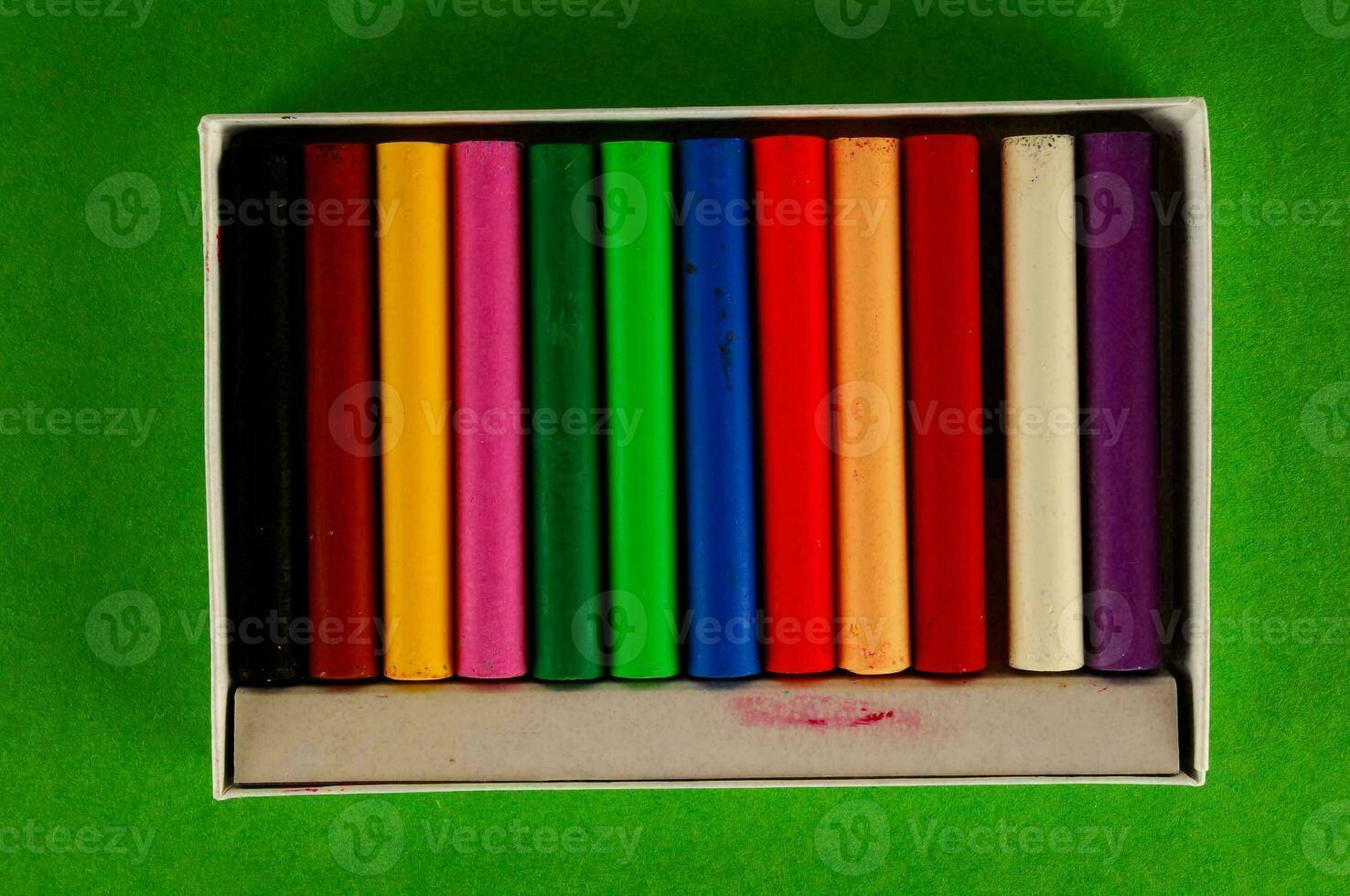en låda av färgad krita foto