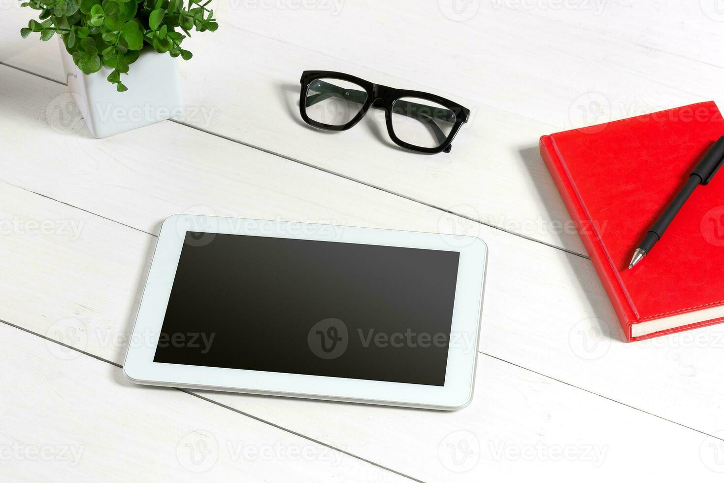 eleganta minimalistisk arbetsplats med läsplatta och anteckningsbok och glasögon i platt lägga stil. vit bakgrund. foto