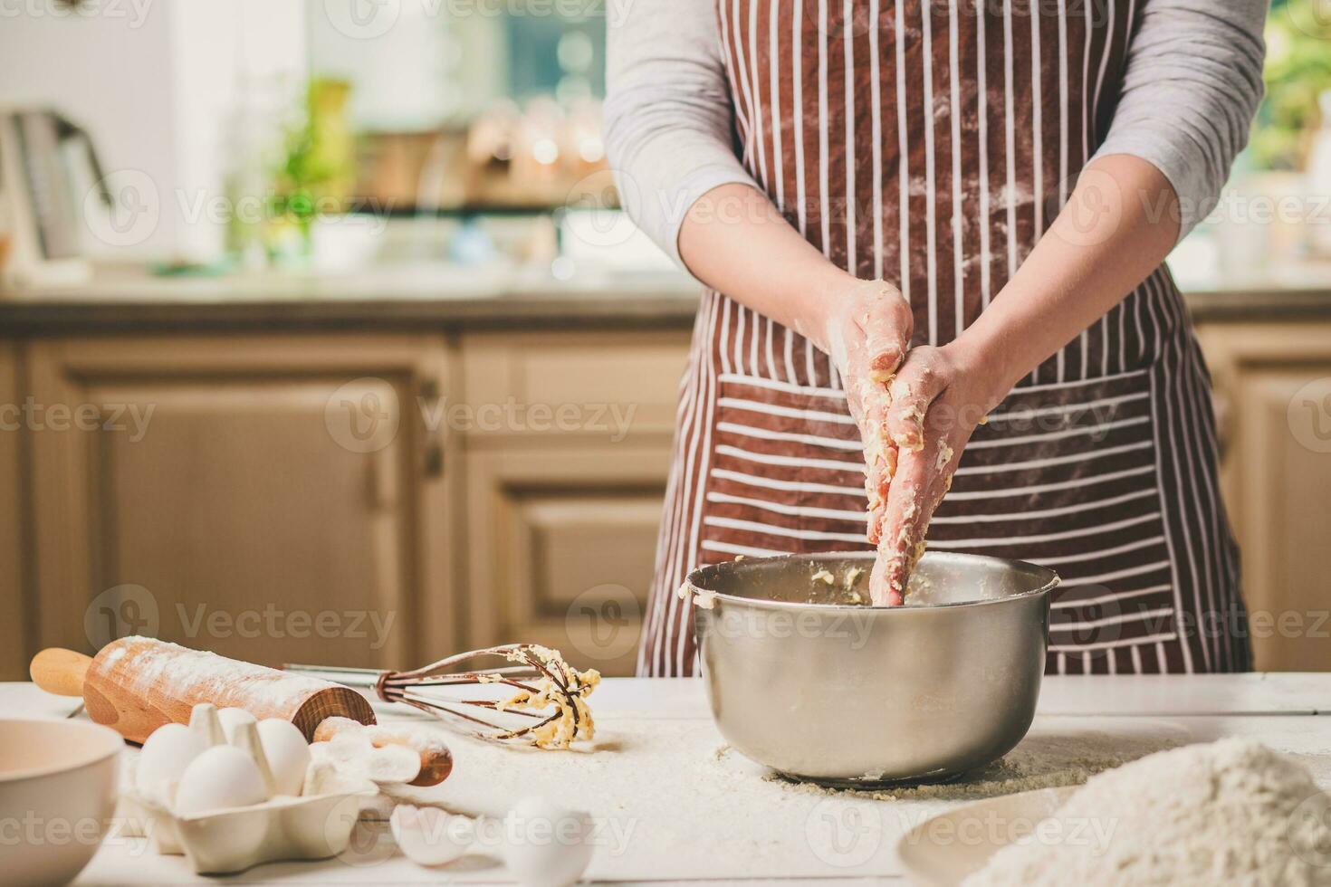 kvinna händer knådning deg i järn skål foto