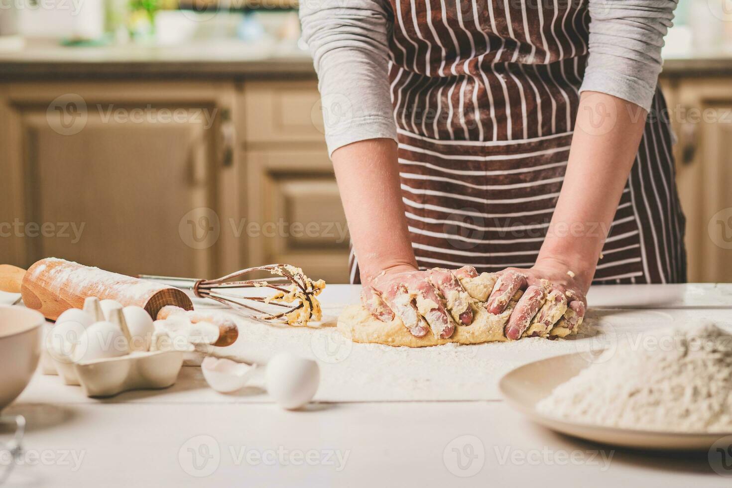 kvinna händer knådning deg på kök tabell foto