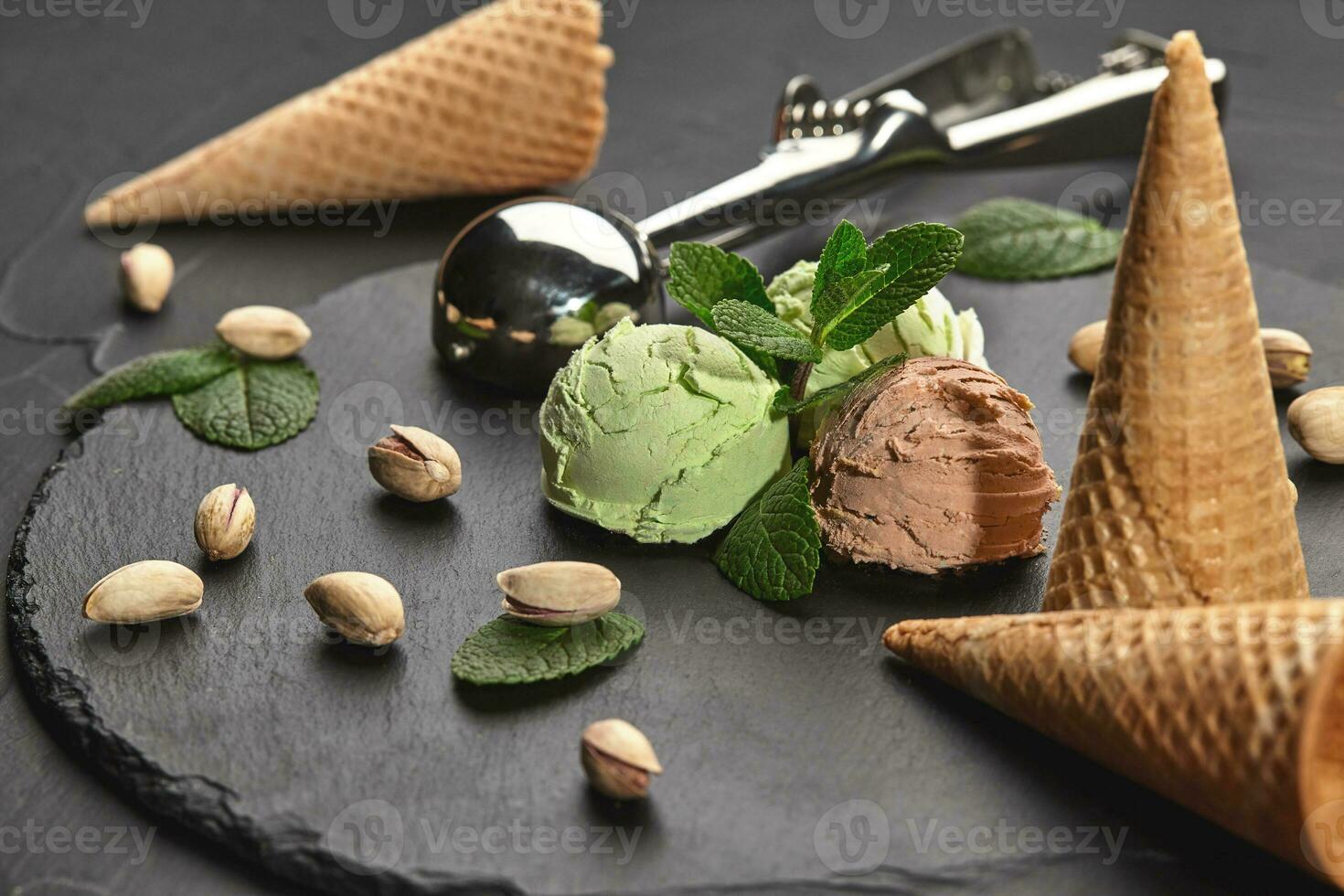 gourmet choklad och pistasch is grädde eras på en sten skiffer över en svart bakgrund. foto