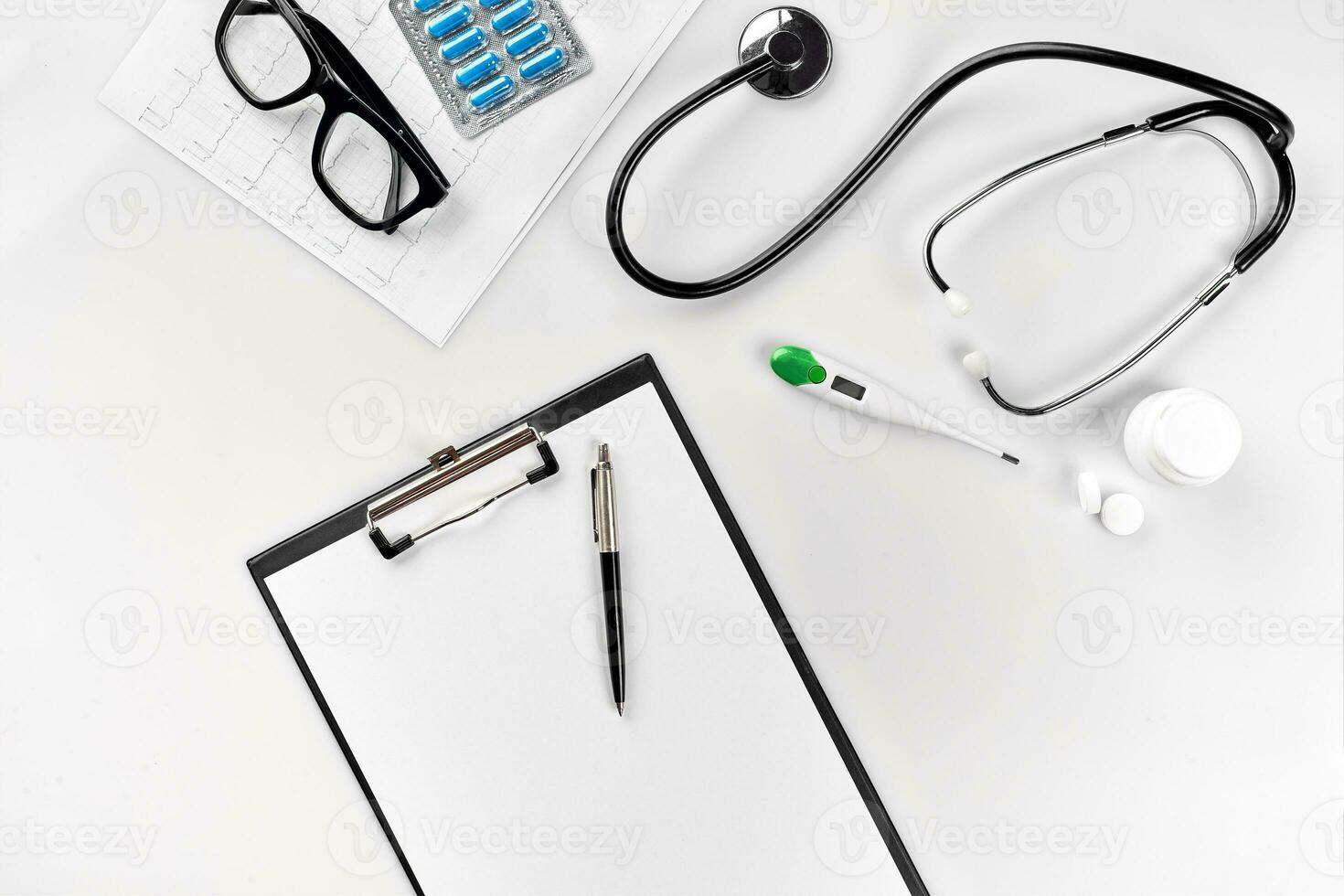 stetoskop i de kontor av läkare.top se av läkares skrivbord tabell, tom papper på Urklipp med penna. kopia Plats. designers tom foto
