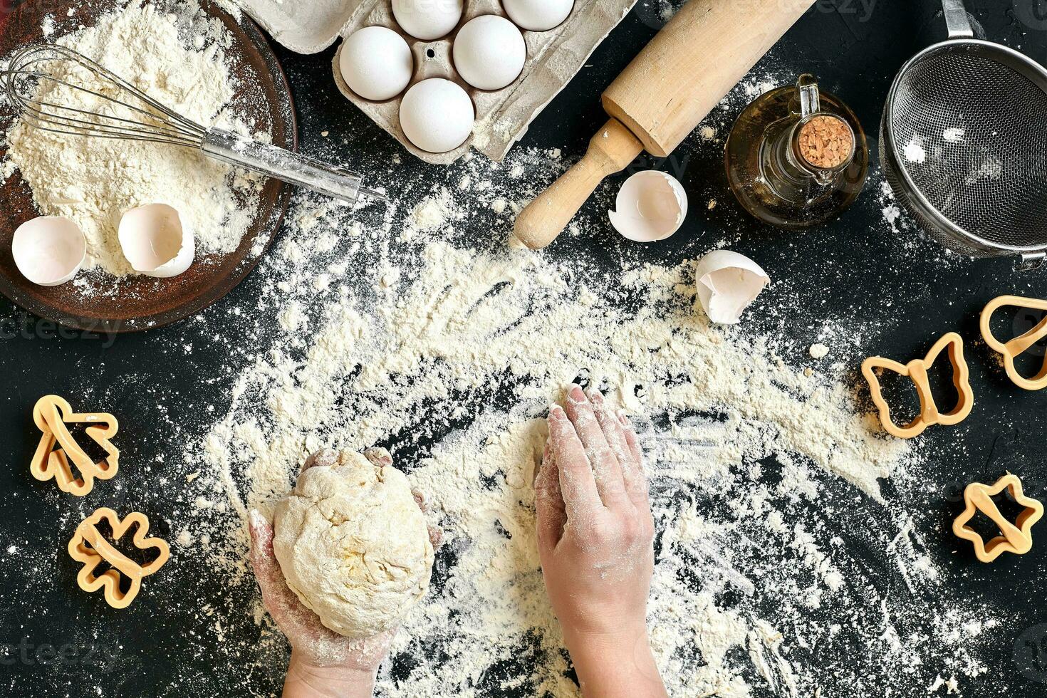 kvinnas händer knåda deg på tabell med mjöl, ägg och Ingredienser. topp se. foto