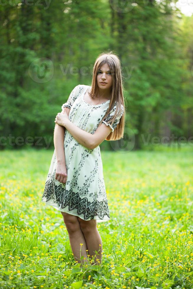 flicka står mitt på en gräsmatta foto