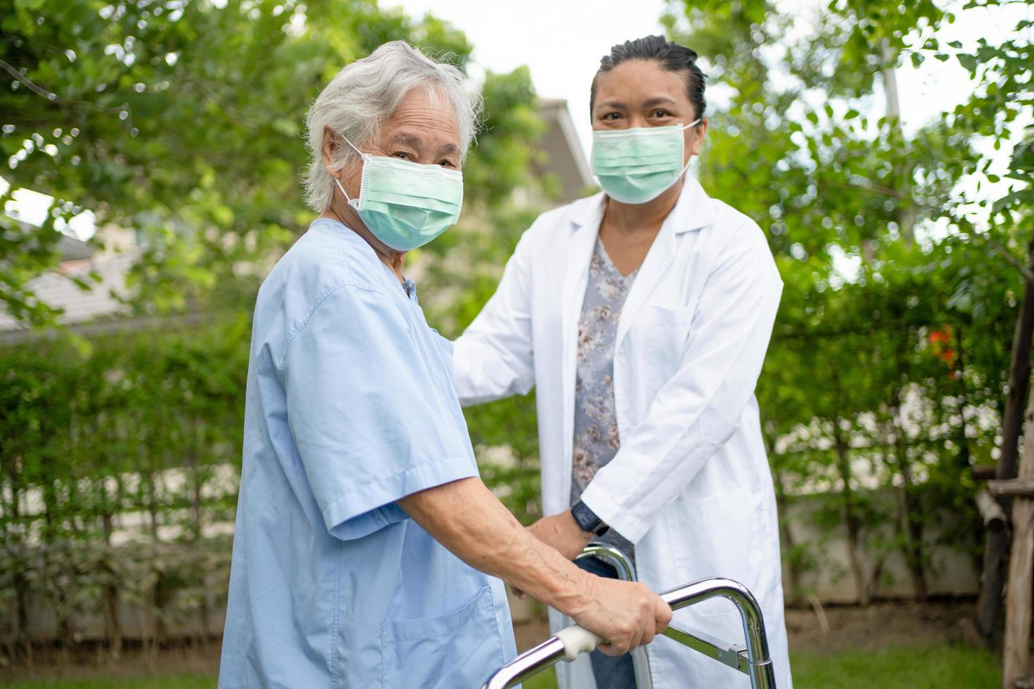 läkare hjälp asiatisk senior kvinna patient på park foto