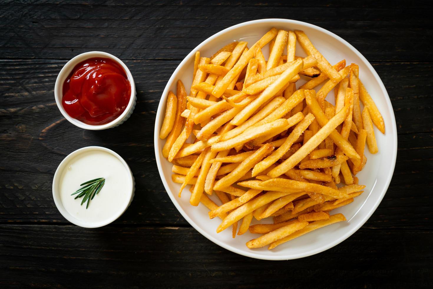 pommes frites med gräddfil och ketchup foto