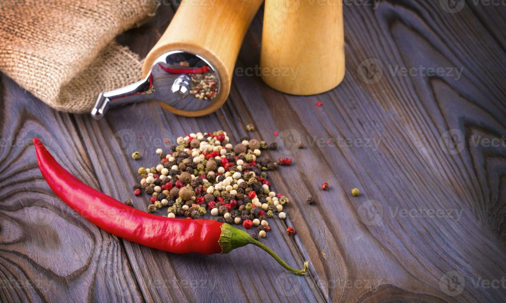 svart peppar liktornar, röd varm chili peppar och svart peppar pulver på trä- bakgrund. foto