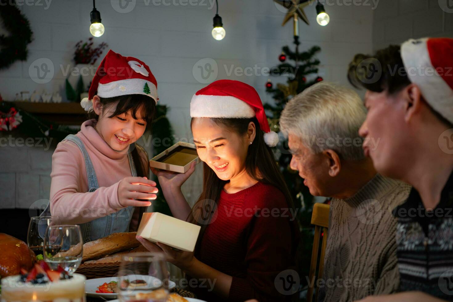 Lycklig asiatisk familj fira jul på Hem. med de aktivitet av ger gåvor till varje Övrig bland familj medlemmar foto