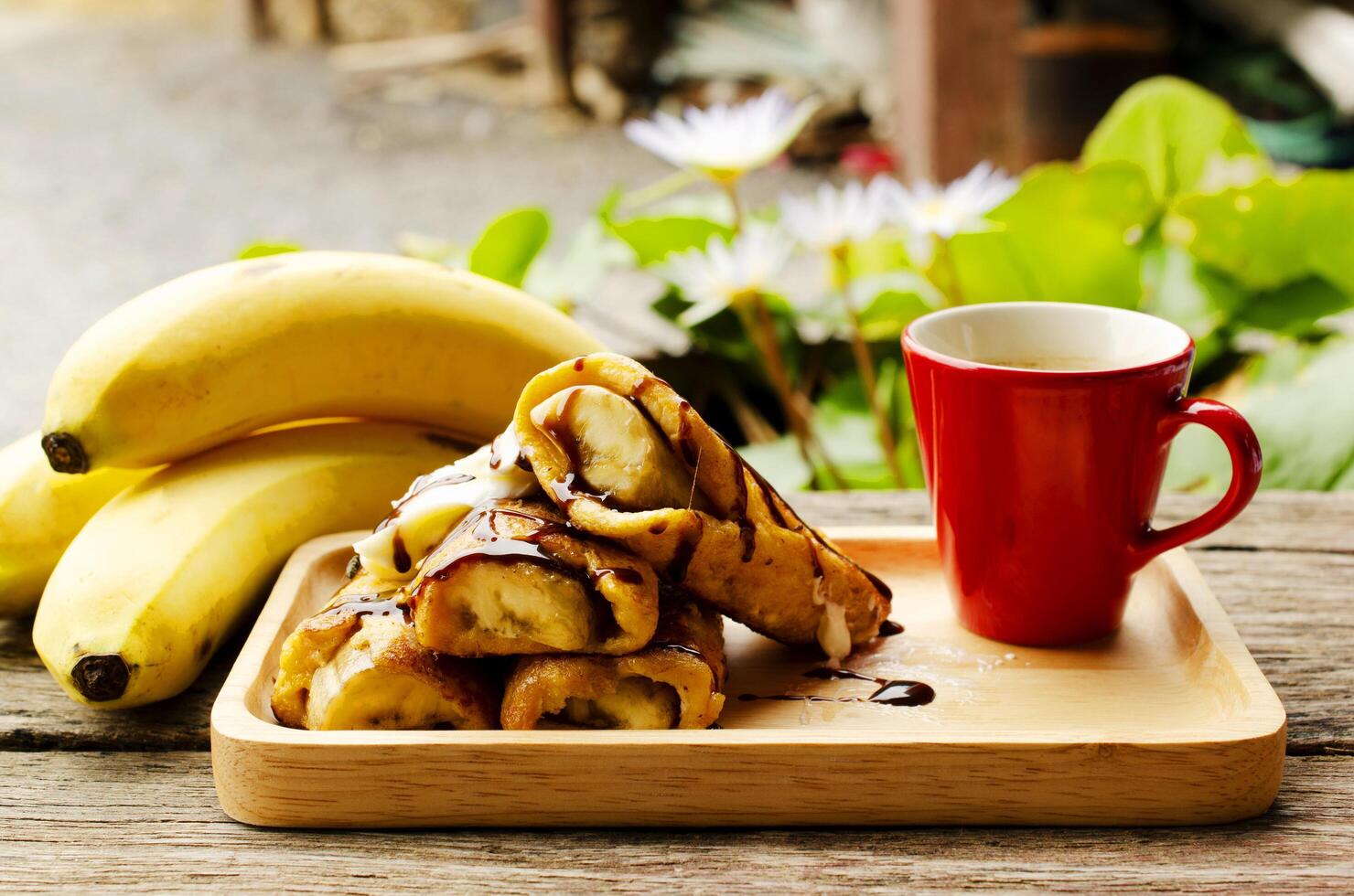 närbild av fransk toast med bananfrukter och röda kaffekoppar foto