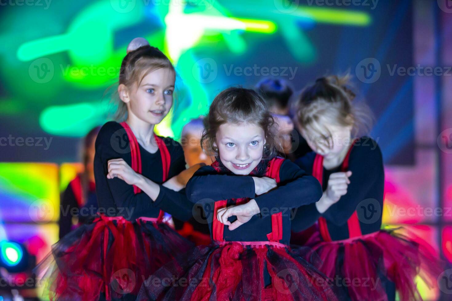 liten flickor är utför en dansa siffra. dansa för helovinna i röd kostymer. flicka dans. emotionell prestanda av en barns dansa grupp. foto