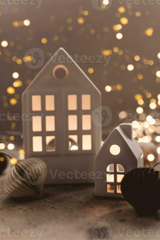 jul bakgrund med vit keramisk hus och papper ballon en bakgrund. jul bakgrund med krans lampor bokeh foto