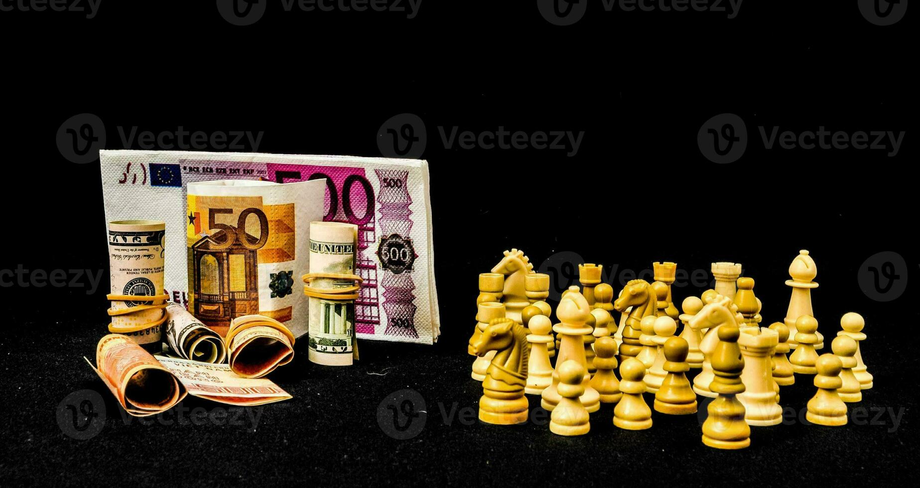 en lugg av pengar och schack bitar på en svart bakgrund foto