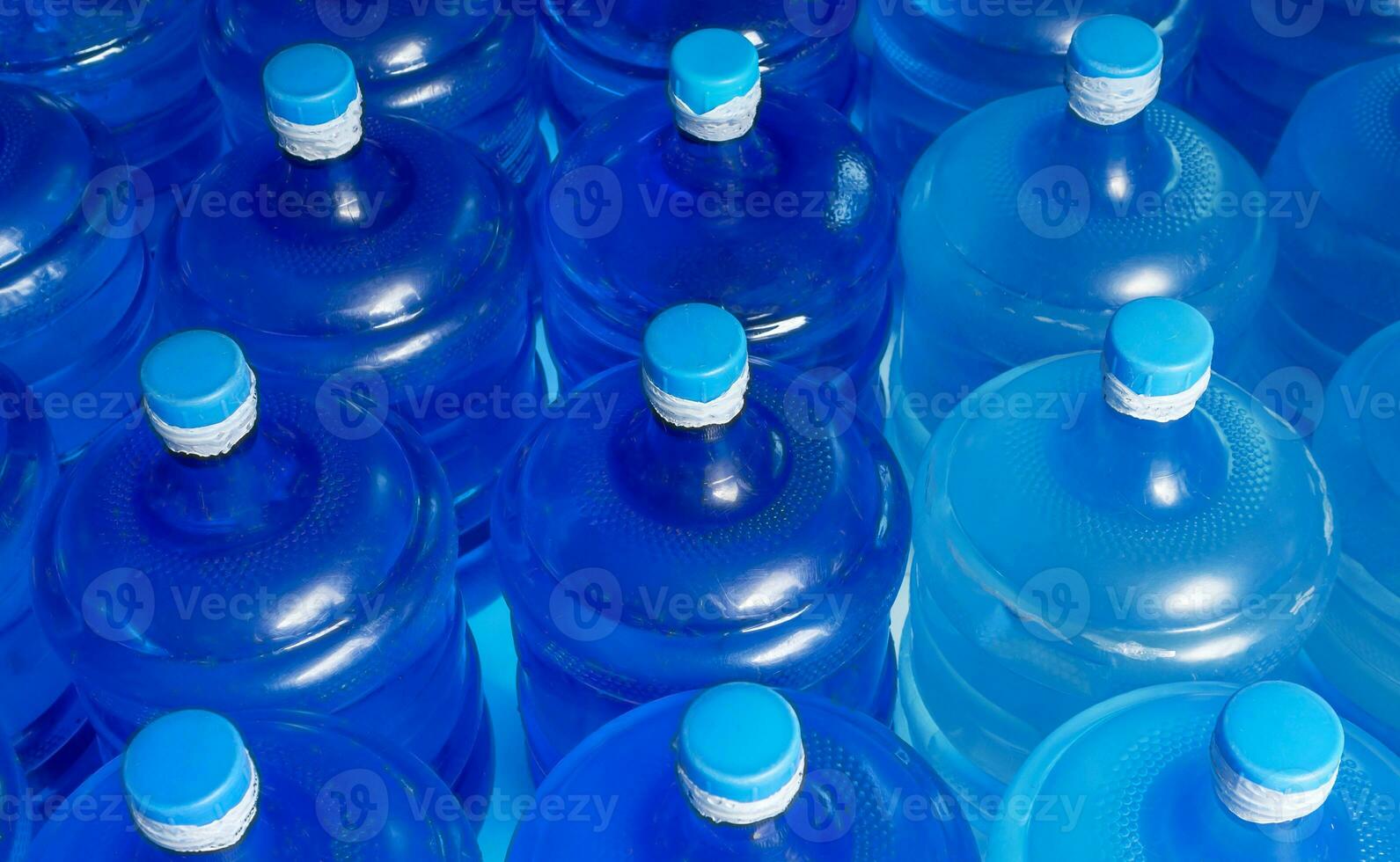 topp se av fodrad upp plast stor flaskor blå liter av renades dricka vatten inuti de produktion linje. vatten dryck fabrik foto