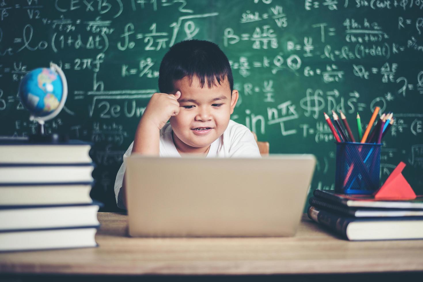 barn använder dator laptop i klassrummet. foto