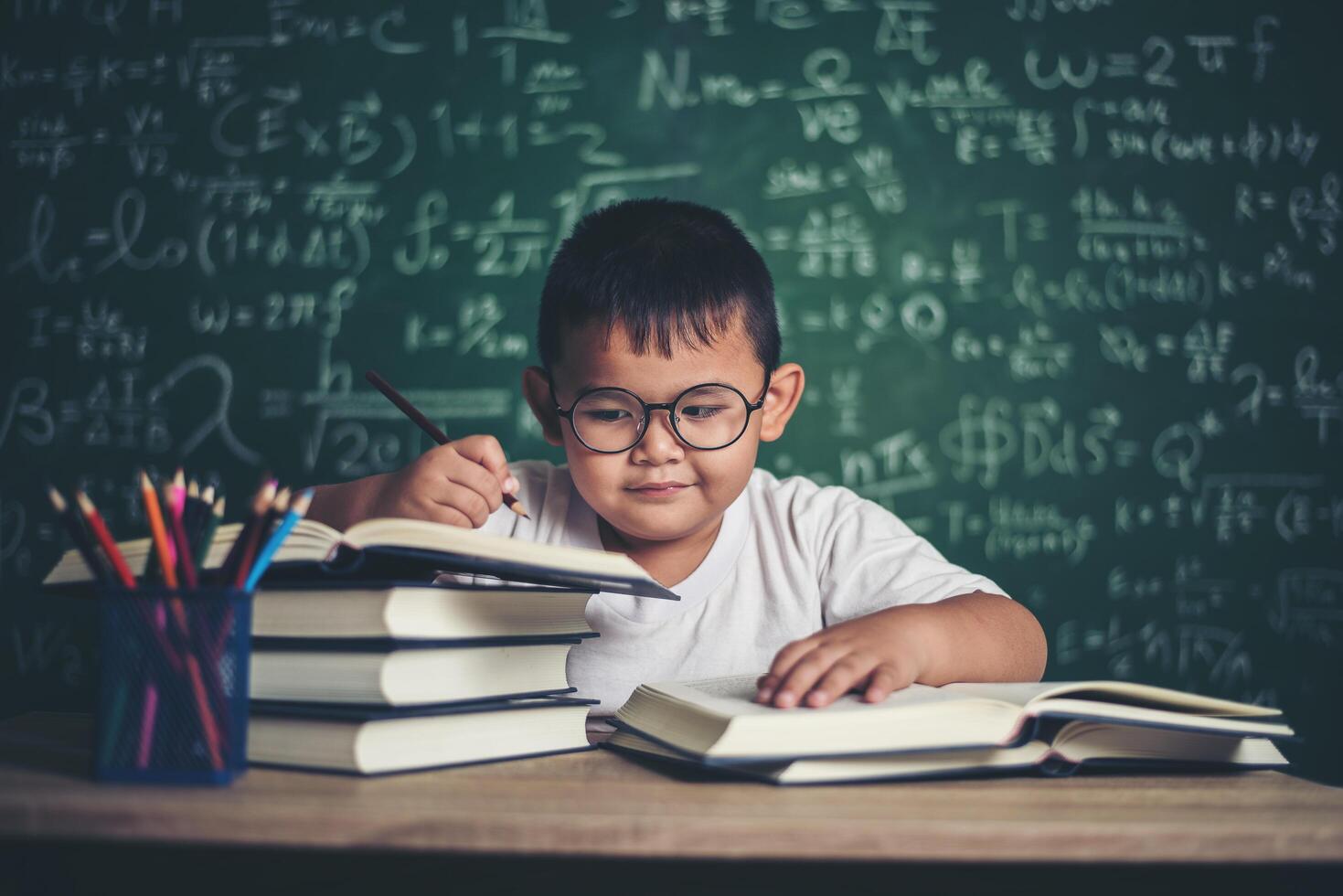 pojke skriva en bok i klassrummet. foto