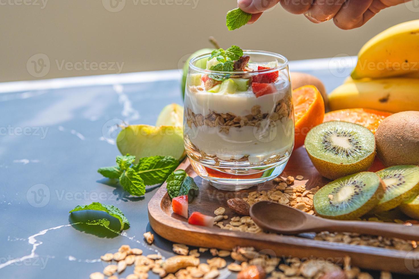 näring näring yoghurt med många frukter på bordet och kocken hand foto