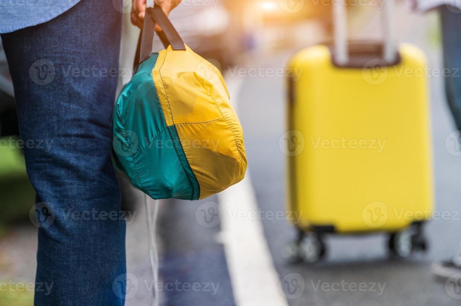 närbild av turistben som går längs vägen med väskan under resan foto