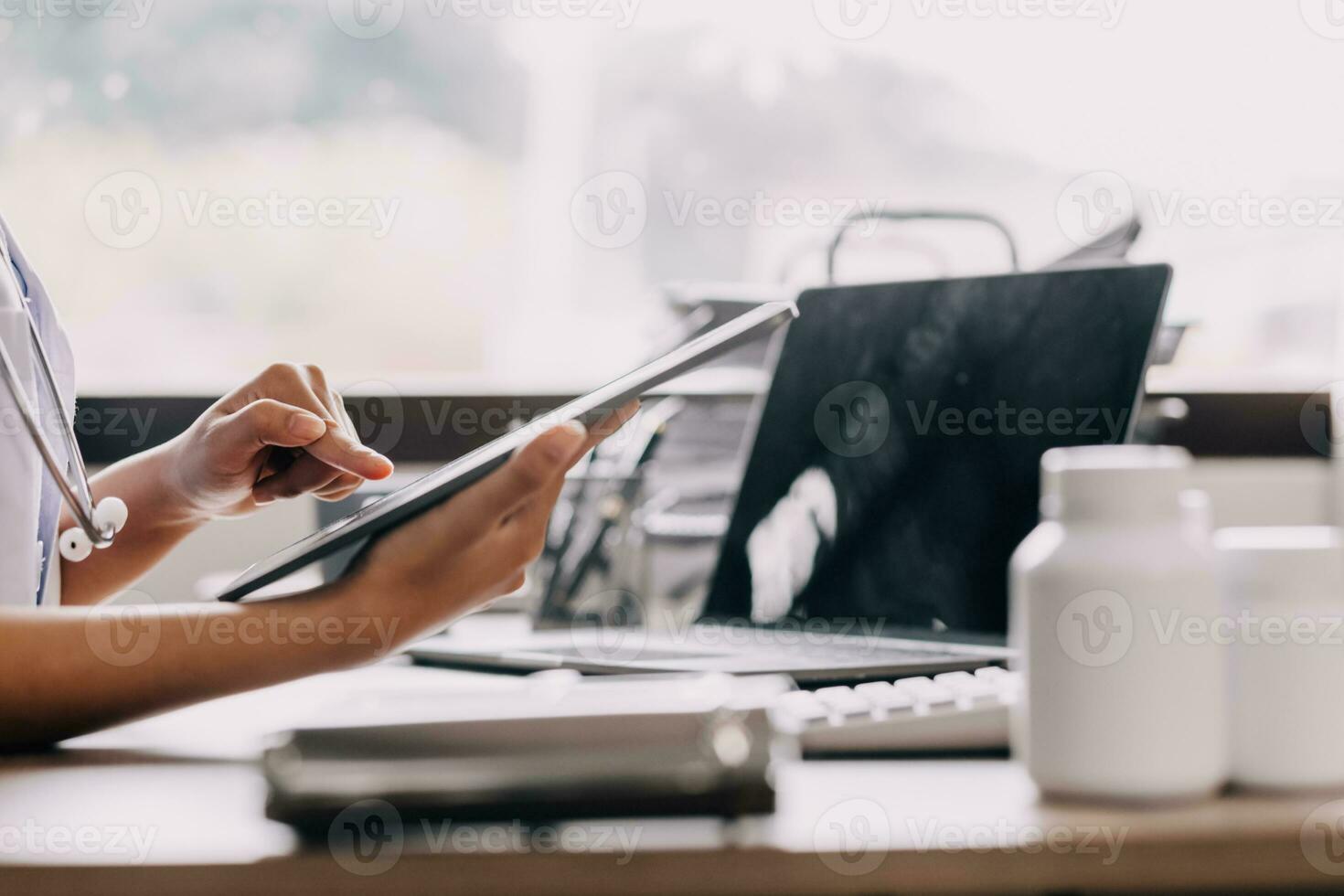 bekymrad ung kvinna caucasian läkare i vit medicinsk enhetlig sitta på skrivbord i sjukhus arbete på bärbar dator, fokuserade kvinna sjuksköterska eller gp upptagen fylla anamnes på dator grej, medicin, teknologi begrepp foto